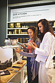Women with smart phone shopping in home goods store