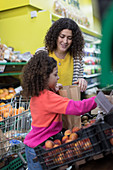 Mother and daughter grocery shopping in supermarket