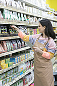 Female grocer with digital tablet working in supermarket