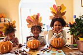 Cute brother and sisters making autumn crafts at table