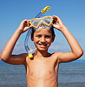 Smiling boy removing snorkel and goggles