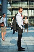Businessman smiling outside urban buildings