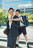 Businesswoman and son hugging in urban park