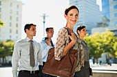 Confident businesswoman with colleagues outdoors