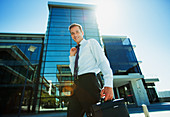 Smiling businessman below highrise