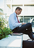 Businessman working on laptop outdoors