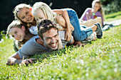 Daughters tackling father in grass