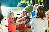 Smiling family toasting mugs at campsite