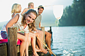 Smiling family with fishing nets on dock over lake