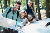 Family looking at map in woods