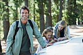 Smiling man with family in woods