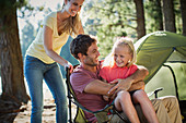 Smiling family at campsite in woods