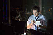 Businessman eating take out food in office at night