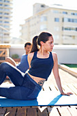 Young woman practicing yoga on sunny urban rooftop