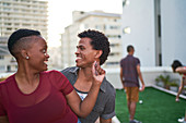 Happy young couple dancing on urban rooftop