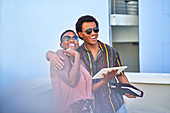 Happy young couple with digital tablet on balcony