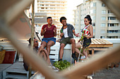 Young friends hanging out on urban rooftop balcony