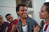 Happy young friends hanging out on sunny patio