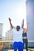 Young women practicing yoga on sunny urban rooftop balcony
