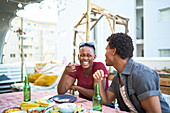 Happy young couple eating lunch at patio table