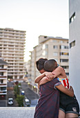 Happy young couple hugging on urban balcony