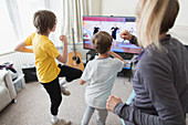 Family exercising at TV in living room