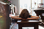 Boy relaxing on bench in kitchen