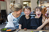 Portrait happy family with dog at dinner table