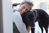 Portrait happy woman hugging dog