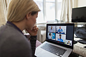 Woman video chatting with doctors at laptop from home
