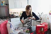 Woman unwrapping groceries in kitchen