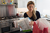 Woman unloading groceries in kitchen