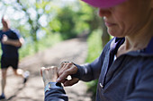 Female jogger with smart watch on trail