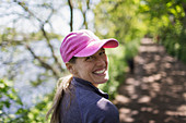 Portrait happy woman hiking on sunny trail