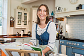 Happy teenage girl cooking in kitchen