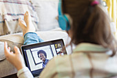 Teenage girl video chatting with friends on laptop screen