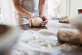 Woman preparing dough in kitchen