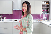 Portrait confident Indian woman in kitchen