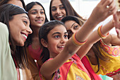 Smiling Indian women and girls in saris taking selfie