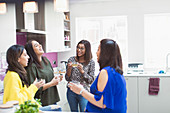 Women talking and drinking tea in kitchen