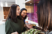 Happy Indian women preparing food in kitchen