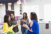 Indian women talking and drinking tea in kitchen