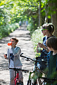 Mother and sons drinking water on bike ride