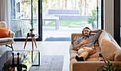 Man relaxing on living room sofa