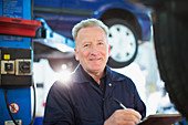 Portrait confident male mechanic with clipboard