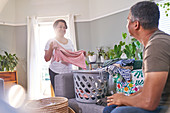Mature couple talking and folding laundry