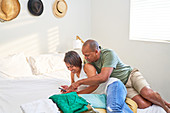Couple using smart phone on bed