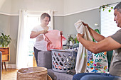 Mature couple folding laundry in living room