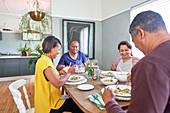 Mature couple friends eating lunch at dining table