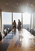 Business people standing at conference room window